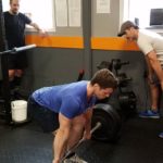 professional barbell coach teaching the Deadlift to client